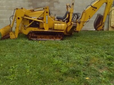 Yellow Caterpillar 305.5E2 mini excavator with cab and tracked undercarriage on grass.