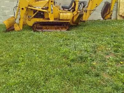 Yellow Caterpillar 305E2 mini excavator with cab and tracks on grass.