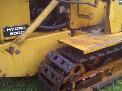 Close-up of Caterpillar Hydro 6000 compact track loader with visible tracks and hydraulic components.