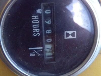 Round vintage hour meter with mechanical display showing 1740.8 hours, used for machinery tracking.