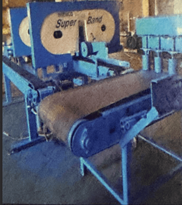 Blue industrial bandsaw with conveyor belt and control panel in workshop setting.