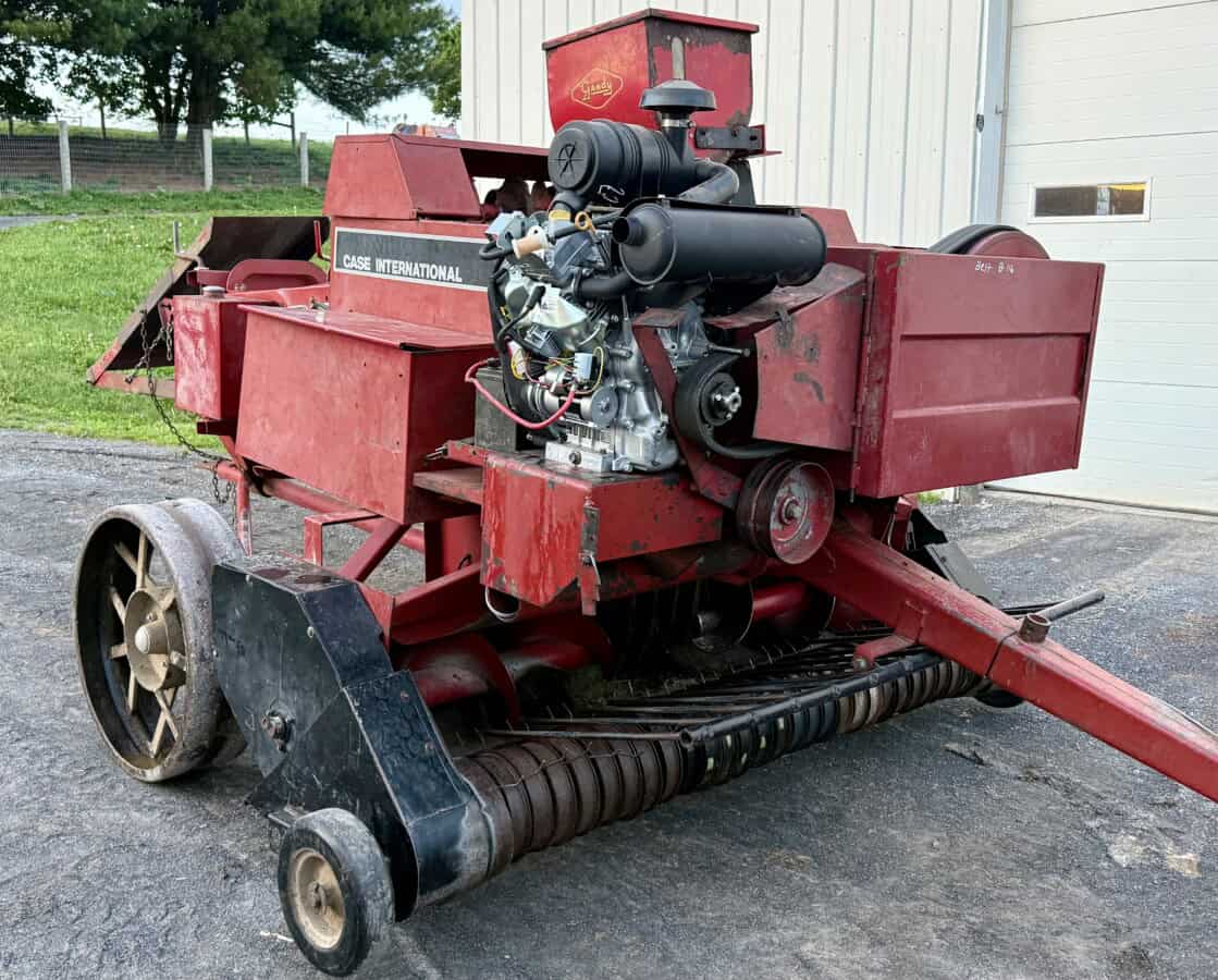 Red Case International forage harvester with engine and feeding mechanism.