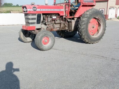 Red Massey Ferguson 1130 tractor with cab and large rear tires on asphalt.