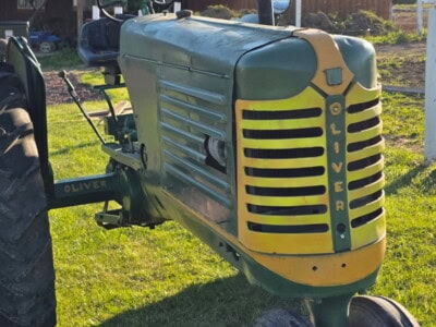 Oliver 77 tractor with green body and yellow grille, vintage farm equipment.