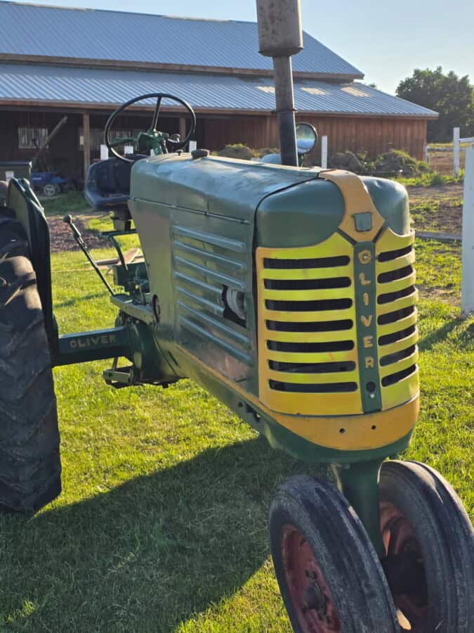 Oliver 77 tractor with green body and yellow grille, vintage farm equipment.