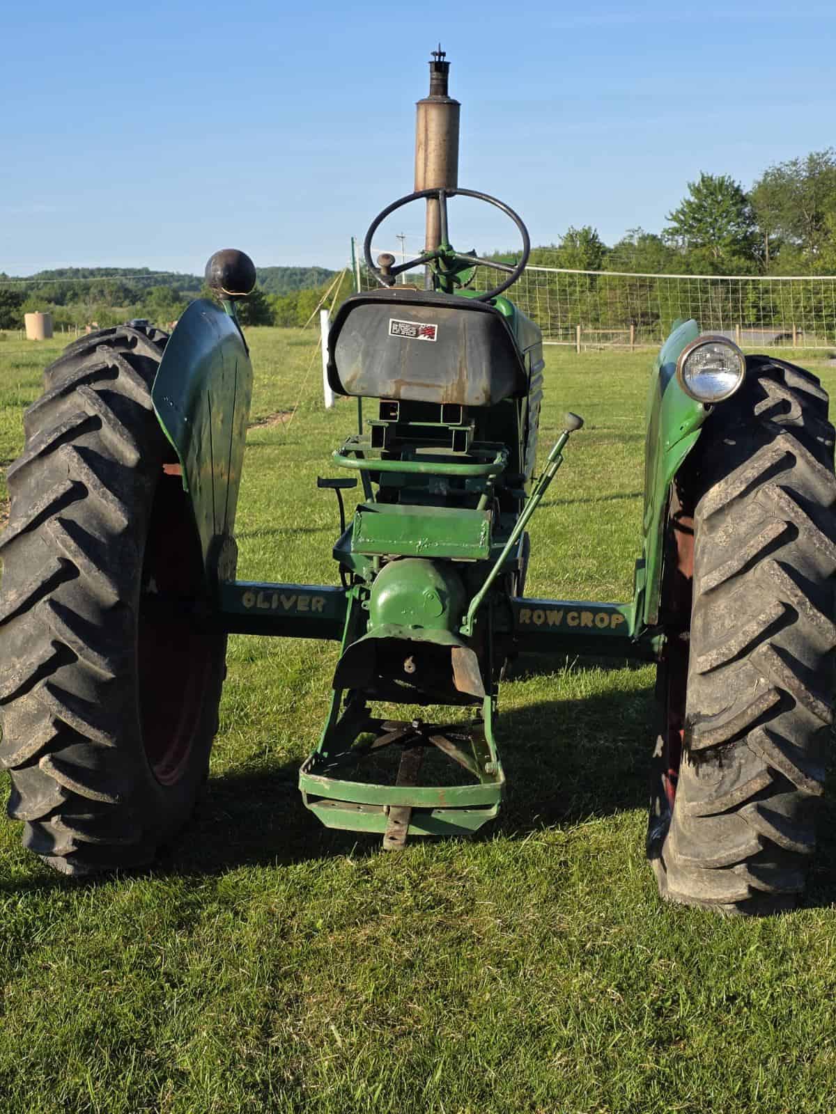 image000002 (3) Green Oliver 77 tractor with large rear tires and front steering wheel on grassy field.
