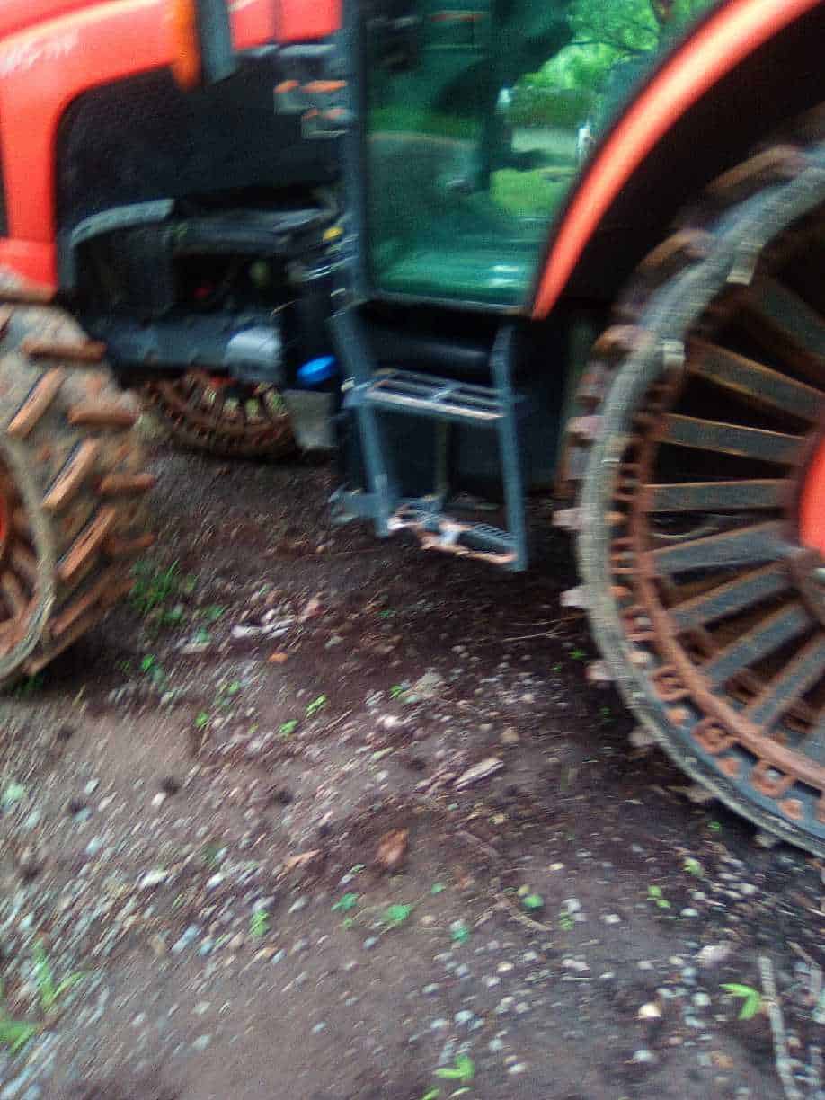 image000004 (1) 2018 Kubota M5-111 tractor with enclosed cab and large tracks for rough terrain.
