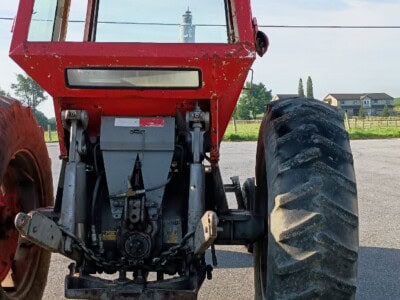 Red Massey Ferguson 1130 tractor with enclosed cab and large rear tires.