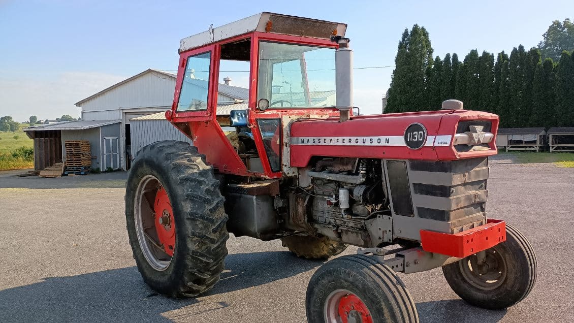 Massey Ferguson 1130 tractor with enclosed cab and large rear tires.