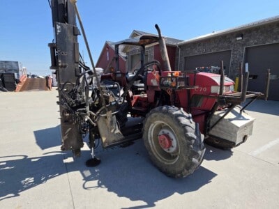 Red McCormick C70 tractor with log cabin pro driver attachment and large rear tires.