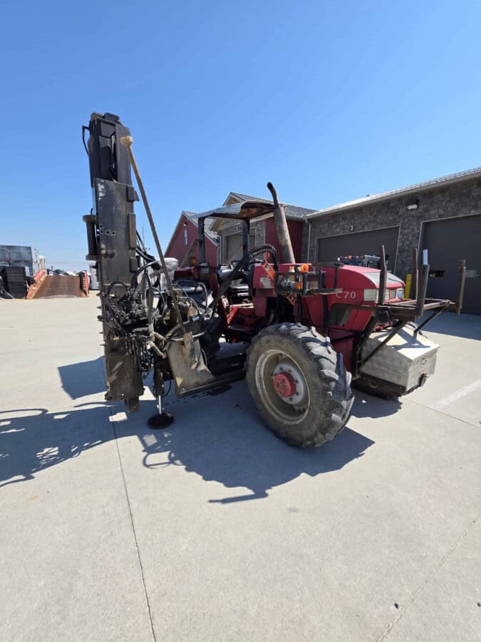 Red McCormick C70 tractor with log cabin pro driver attachment and large rear tires.