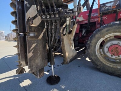 McCormick C70 tractor with Log Cabin Pro Driver attachment and hydraulic controls.