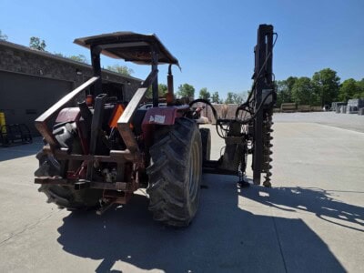 McCormick C70 tractor with Log Cabin Pro Driver attachment, large tires, and protective canopy under clear blue sky.