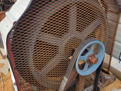 Old circular sawmill with metal guard and large blade, outdoor setting, part of woodworking equipment collection.