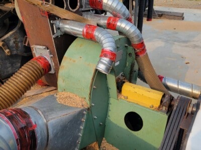 Industrial dust collection system with flexible hoses and metal ductwork for woodworking shop.