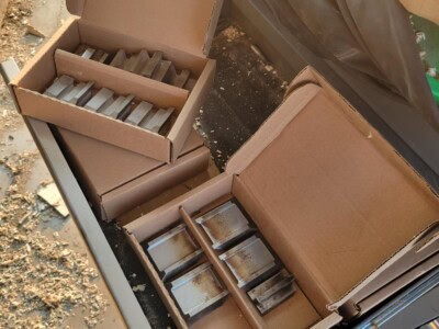 Assorted metal blades in boxes for sawmill machinery.