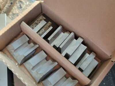 Set of metal blades for circular sawmill and planer machinery in a cardboard box.