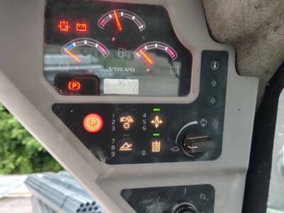 Volvo MC85C control panel with warning lights and gauges, showing engine and hydraulic status.