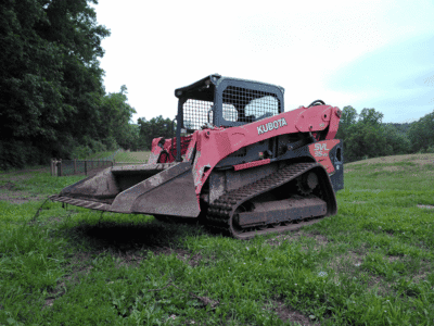 2018 Kubota SVL95-2 compact track loader with enclosed cab and bucket attachment on grassy field.