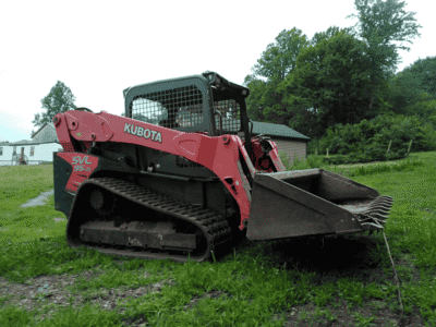 2018 Kubota SVL95-2 compact track loader with bucket attachment on grassy field.