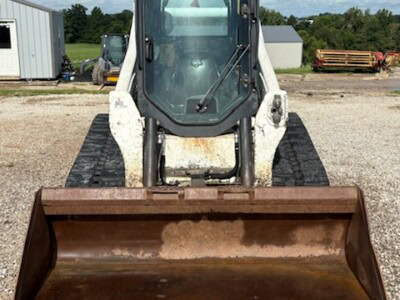 2018 Bobcat T650 with enclosed cab and front bucket attachment on gravel surface.