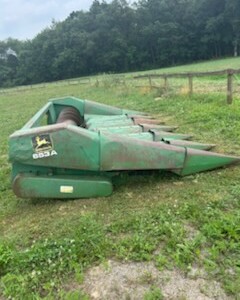 John Deere 653 6-Row All-Crop Head with green paint and cutting blades, used for harvesting crops.