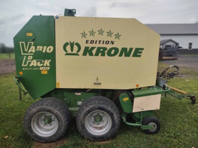 Krone Vario Pack round baler with green and white exterior, large tires, and branding visible.