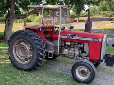 Red Massey Ferguson 285 tractor with enclosed cab and large rear tires.