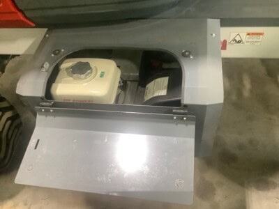 Close-up of equipment fuel tank and access panel with open cover.