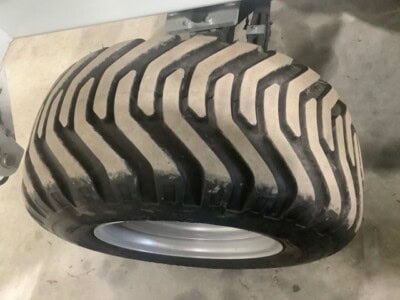 Close-up of large heavy-duty construction equipment tire with deep treads.