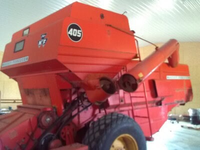 Red Massey Ferguson 405 round baler with large tires and baling chamber.