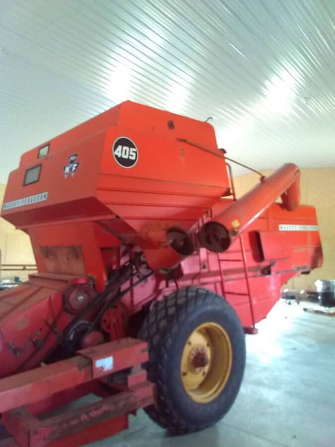 Red Massey Ferguson 405 round baler with large tires and baling chamber.