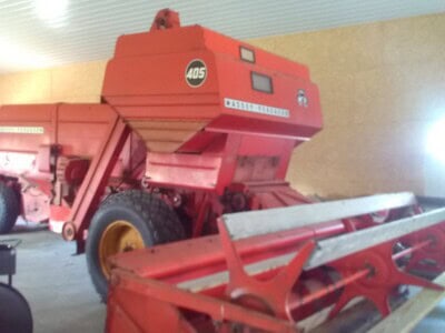 Red Massey Ferguson 405 hay baler with large pickup reel and enclosed chamber.