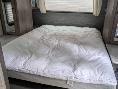 Interior of 2021 Forest River Surveyor 203RLKE travel trailer with bed and window blinds.