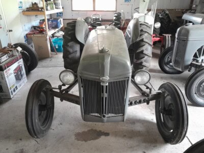 1939 Ford 9N tractor with front grille and large rear tires in a workshop.