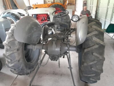 1939 Ford 9N vintage tractor with large rear tires and steering wheel, inside workshop setting.