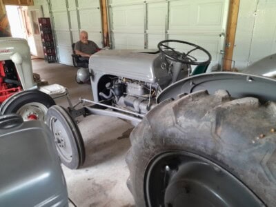 1939 Ford 9N tractor with a man sitting nearby in a garage.