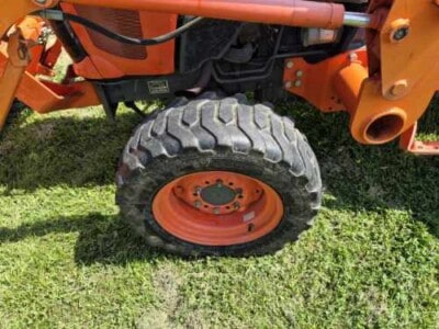 Close-up of the rear wheel of a Kubota L3800D compact tractor on grass.