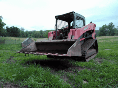 2018 Kubota SVL95-2 compact track loader with front bucket on grassy field.