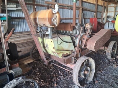 Rusty vintage Deutz F6L912 diesel engine on a wheeled frame in a shed.