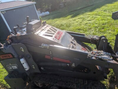 2023 Lynx LX-1200 compact track loader with cab and tracks in a grassy yard.