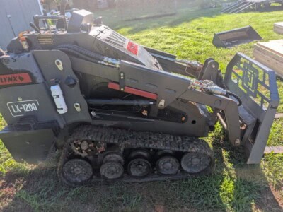 2023 LYNX LX-1200 compact track loader with rubber tracks and front attachment in grassy area.