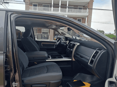Interior view of a pickup truck showing dashboard, steering wheel, and front seats.