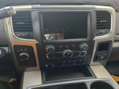 Interior dashboard of a vehicle with touchscreen display and control knobs.