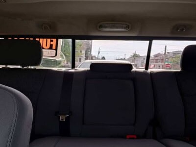 View of the rear passenger seats and rear window inside a vehicle.