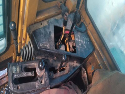 Interior of a John Deere 748 tractor with gear shift and control levers.