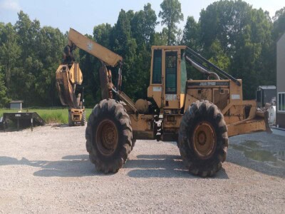John Deere 748 wheel loader with front bucket and rear excavator arm on gravel lot.