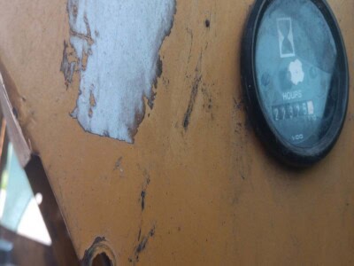 Close-up of a worn yellow John Deere equipment dashboard with hour meter.