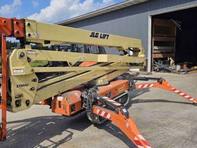 2015 JLG X700AJ boom lift with extended boom and stabilizers on concrete surface.