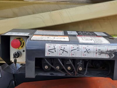 Construction equipment control panel with safety labels and switches.